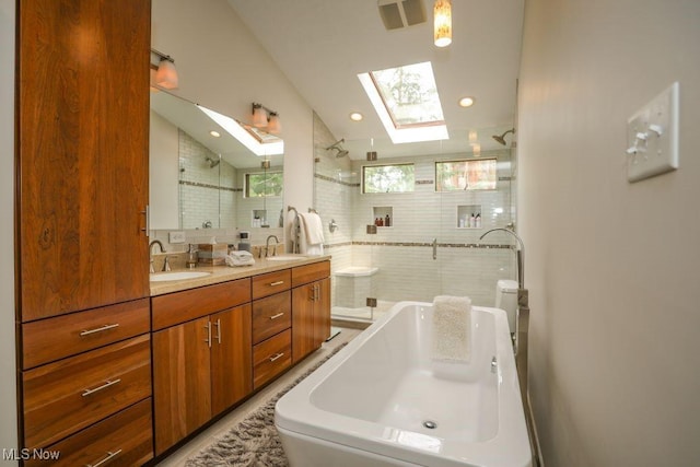 1367 Mockingbird Dr, Kent, OH 44240 - full bath featuring a skylight, vaulted ceiling, a tile shower, a tub, and double vanity