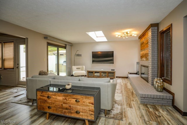 1367 Mockingbird Dr, Kent, OH 44240 - living room featuring a skylight, wood finished floors, a brick fireplace, and a textured ceiling