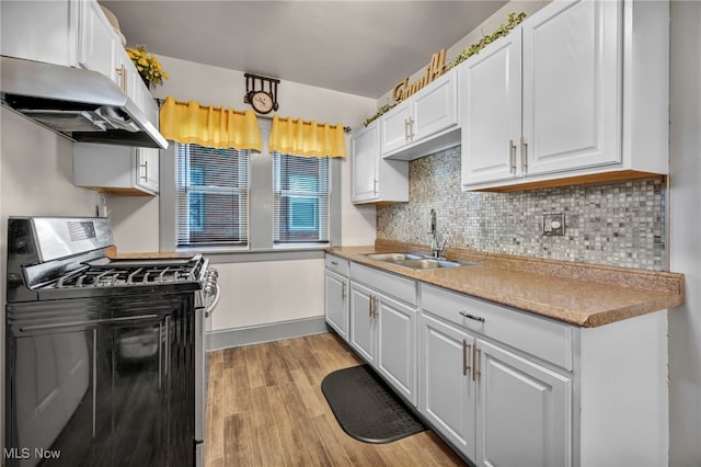 3403 Hartwood Rd, Cleveland Heights, OH 44112 - kitchen featuring stainless steel range with gas stovetop, a sink, under cabinet range hood, white cabinetry, and light wood finished floors