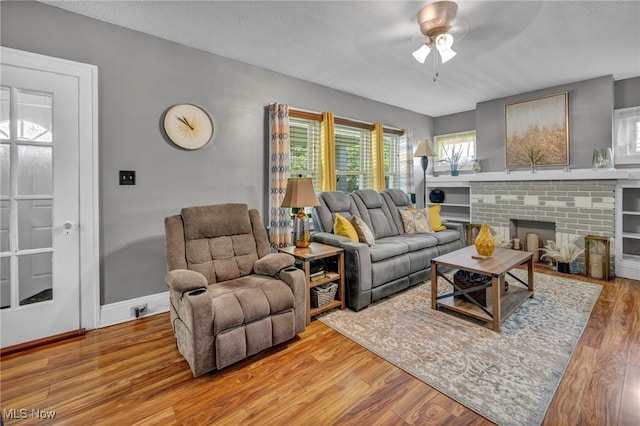 3403 Hartwood Rd, Cleveland Heights, OH 44112 - living room with a ceiling fan, wood finished floors, baseboards, and a brick fireplace