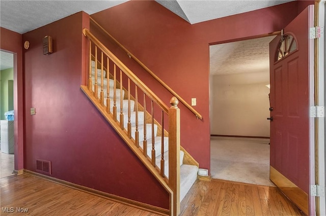 3277 Plainview Rd, Ravenna, OH 44266 - stairway featuring wood finished floors, a textured ceiling, and baseboards