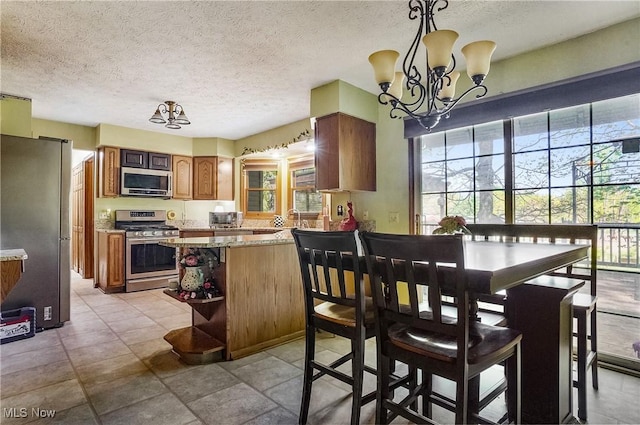 3277 Plainview Rd, Ravenna, OH 44266 - dining space with healthy amount of natural light, a chandelier, and a textured ceiling