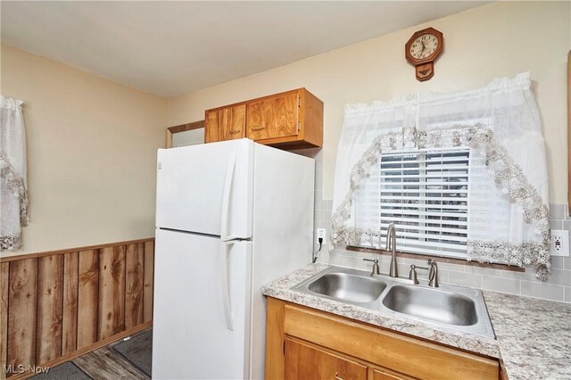 1658 Bronson Rd, Akron, OH 44305 - kitchen with freestanding refrigerator, a sink, light countertops, brown cabinetry, and wainscoting
