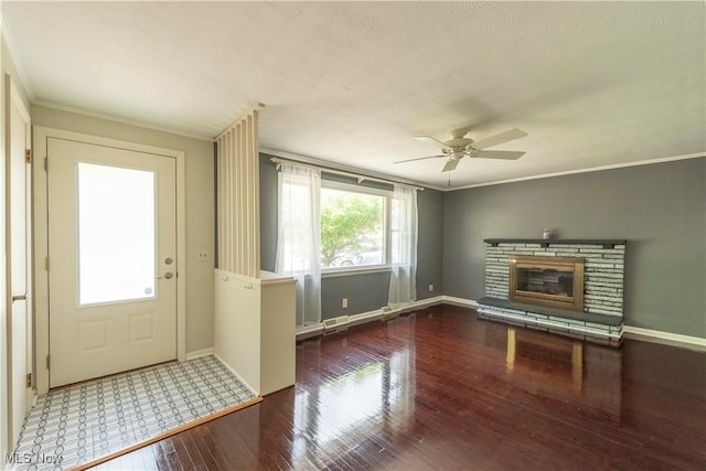 338 Applegrove St NE, North Canton, OH 44720 - unfurnished living room with hardwood / wood-style flooring, ceiling fan, baseboards, a stone fireplace, and ornamental molding