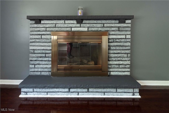338 Applegrove St NE, North Canton, OH 44720 - detailed view of a brick fireplace, baseboards, and wood finished floors