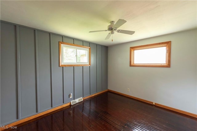 338 Applegrove St NE, North Canton, OH 44720 - unfurnished room with baseboards, hardwood / wood-style floors, ceiling fan, and a decorative wall