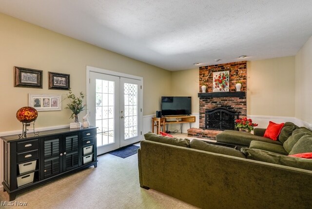 139 Elm Ct, Chagrin Falls, OH 44022 - carpeted living area featuring french doors, a brick fireplace, and a textured ceiling