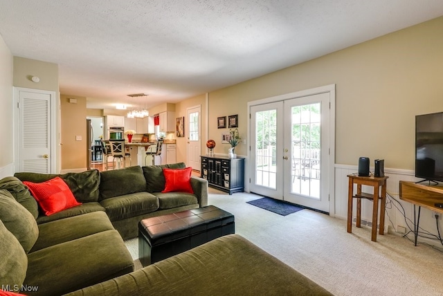 139 Elm Ct, Chagrin Falls, OH 44022 - living room with a chandelier, a wainscoted wall, light carpet, and french doors