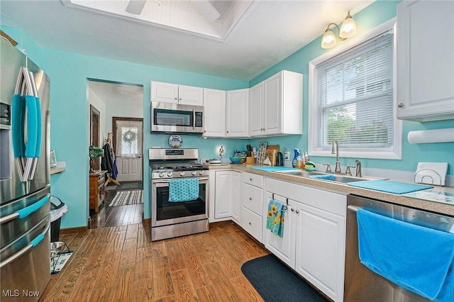 2024 W 10th St, Ashtabula, OH 44004 - kitchen with appliances with stainless steel finishes, a sink, white cabinets, dark wood finished floors, and light countertops