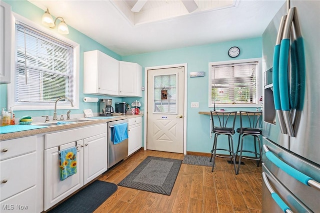 2024 W 10th St, Ashtabula, OH 44004 - kitchen with stainless steel appliances, a sink, white cabinetry, light countertops, and wood finished floors