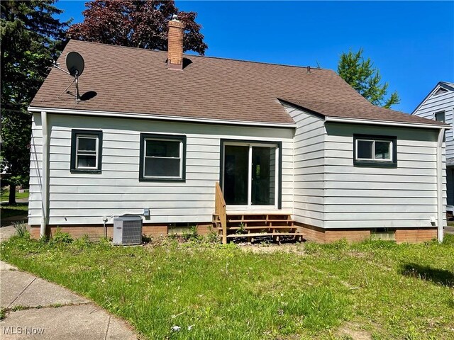 24421 Effingham Blvd, Euclid, OH 44117 - back of house featuring cooling unit, entry steps, roof with shingles, a chimney, and a yard