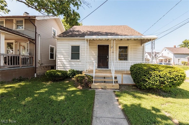 125 E 30th St, Lorain, OH 44055 - bungalow featuring a porch, a front lawn, and a shingled roof