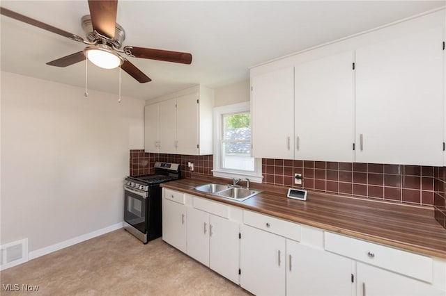 125 E 30th St, Lorain, OH 44055 - kitchen with stainless steel range with gas stovetop, a sink, decorative backsplash, white cabinetry, and a ceiling fan