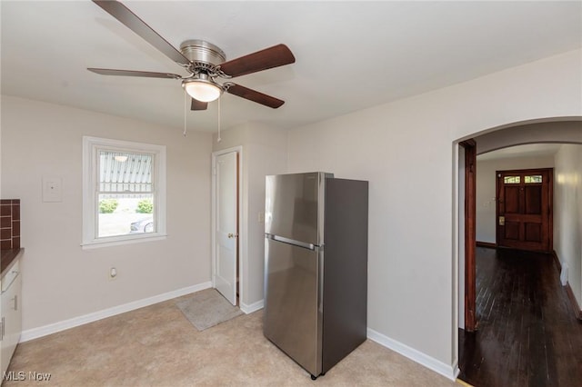 125 E 30th St, Lorain, OH 44055 - kitchen featuring freestanding refrigerator, arched walkways, a ceiling fan, and baseboards