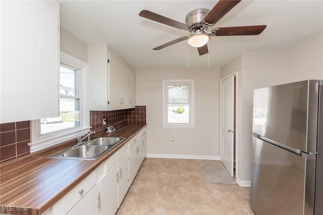 125 E 30th St, Lorain, OH 44055 - kitchen with freestanding refrigerator, a sink, healthy amount of natural light, and white cabinets