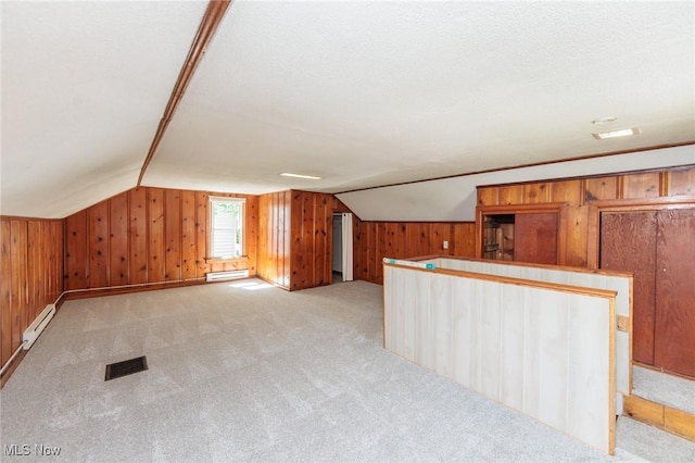 125 E 30th St, Lorain, OH 44055 - additional living space featuring baseboard heating, wooden walls, lofted ceiling, and light colored carpet