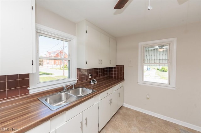 125 E 30th St, Lorain, OH 44055 - kitchen with a sink, backsplash, ceiling fan, and white cabinetry