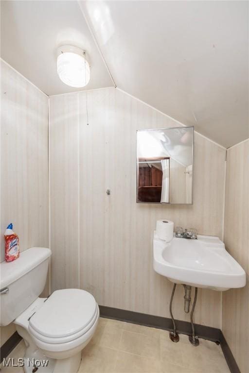 125 E 30th St, Lorain, OH 44055 - bathroom featuring toilet, lofted ceiling, baseboards, and wooden walls