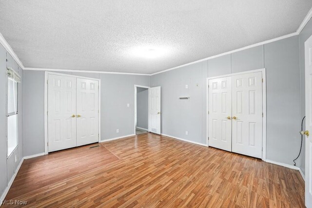 10597 State Route 82, Windham, OH 44288 - unfurnished bedroom featuring crown molding, wood finished floors, a textured ceiling, and baseboards