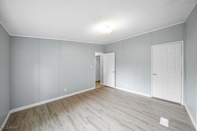 10597 State Route 82, Windham, OH 44288 - unfurnished bedroom with wood finished floors, a textured ceiling, and baseboards