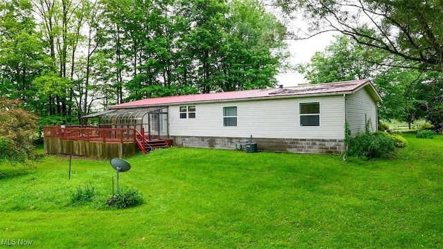 10597 State Route 82, Windham, OH 44288 - back of house featuring a deck and a lawn