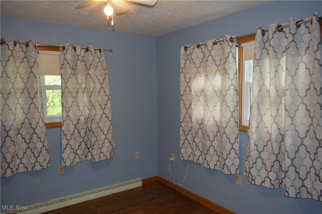 238 E Main St, New London, OH 44851 - unfurnished room with baseboard heating, ceiling fan, wood finished floors, and baseboards