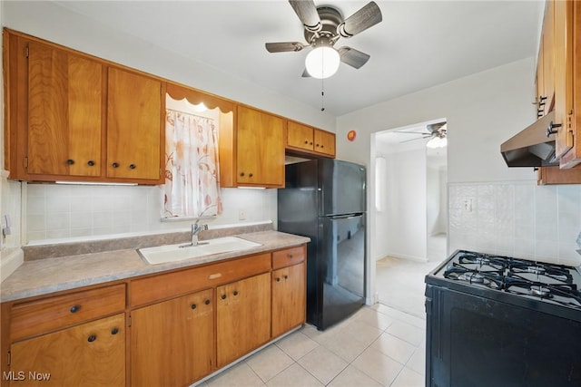 21031 Ball Ave, Euclid, OH 44123 - kitchen with black appliances, a sink, ceiling fan, under cabinet range hood, and brown cabinets