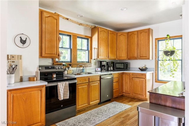 2671 Haddam Rd, Cleveland, OH 44120 - kitchen featuring appliances with stainless steel finishes, a sink, light wood-style flooring, light countertops, and brown cabinetry