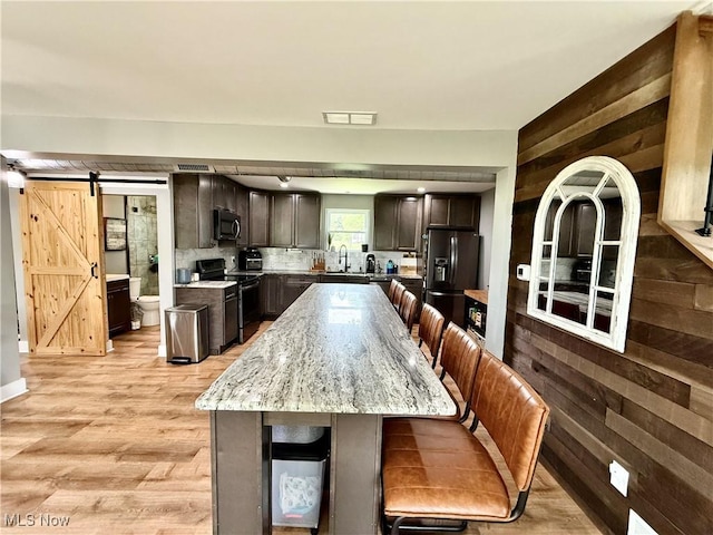 7509 S Palmyra Rd, Canfield, OH 44406 - kitchen featuring stainless steel electric range oven, black fridge with ice dispenser, a sink, a kitchen bar, and dark brown cabinetry