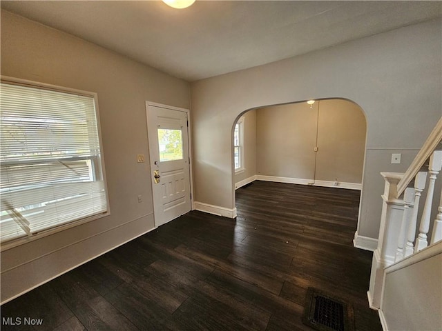 3891 W 21st St, Cleveland, OH 44109 - foyer with arched walkways, dark wood-style floors, stairway, and baseboards