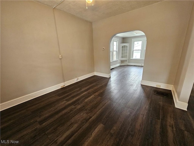 3891 W 21st St, Cleveland, OH 44109 - spare room with arched walkways, dark wood-style floors, and baseboards