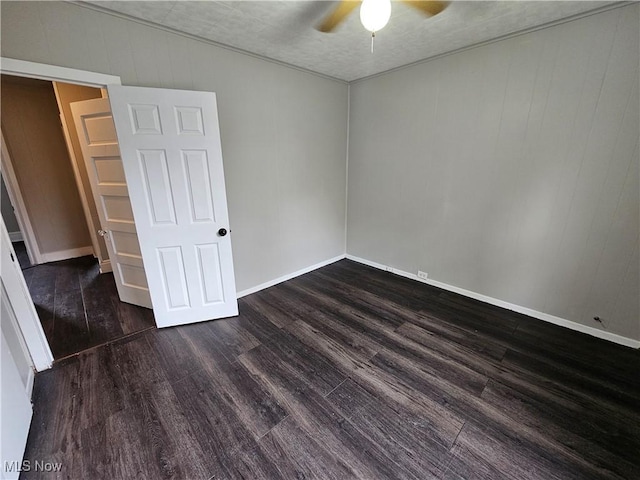 3891 W 21st St, Cleveland, OH 44109 - unfurnished room with ceiling fan, dark wood-type flooring, baseboards, and wooden walls
