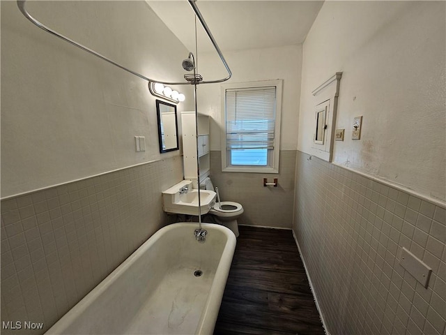 3891 W 21st St, Cleveland, OH 44109 - full bath featuring tile walls, a wainscoted wall, wood finished floors, a tub to relax in, and toilet