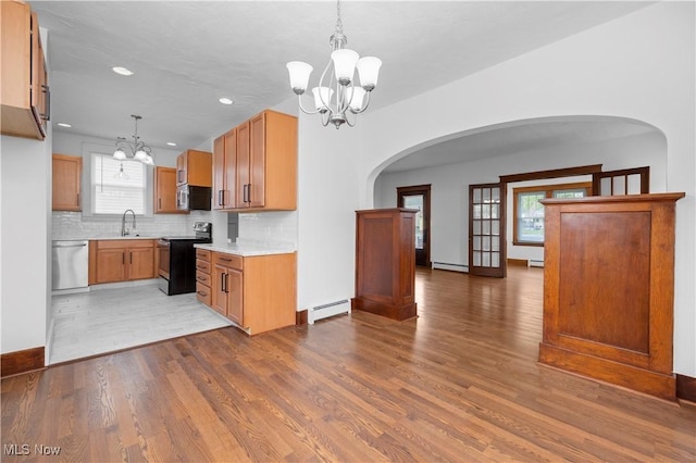 1138 W 6th St, Lorain, OH 44052 - kitchen featuring appliances with stainless steel finishes, a chandelier, wood finished floors, tasteful backsplash, and light countertops