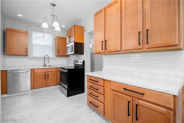 1138 W 6th St, Lorain, OH 44052 - kitchen featuring appliances with stainless steel finishes, a sink, backsplash, hanging light fixtures, and a chandelier