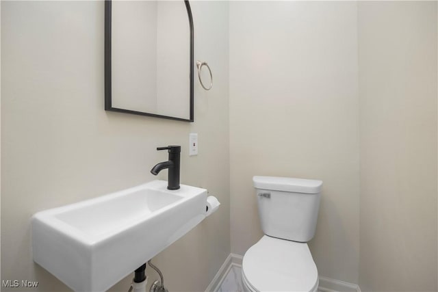 1138 W 6th St, Lorain, OH 44052 - bathroom featuring a sink, baseboards, and toilet