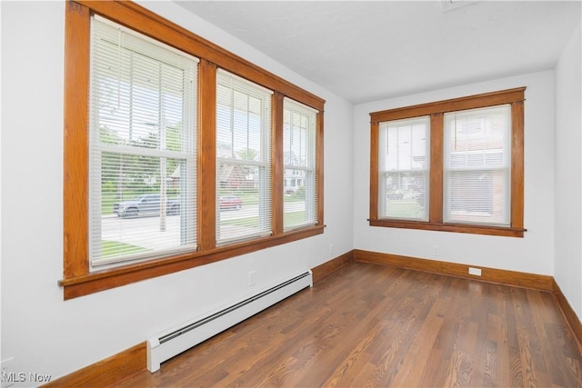 1138 W 6th St, Lorain, OH 44052 - empty room featuring a baseboard heating unit, baseboards, and dark wood-type flooring