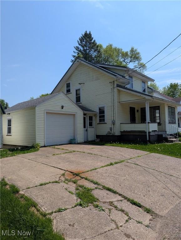 630 N Lincoln Ct, Louisville, OH 44641 - view of front facade featuring driveway, an attached garage, and covered porch