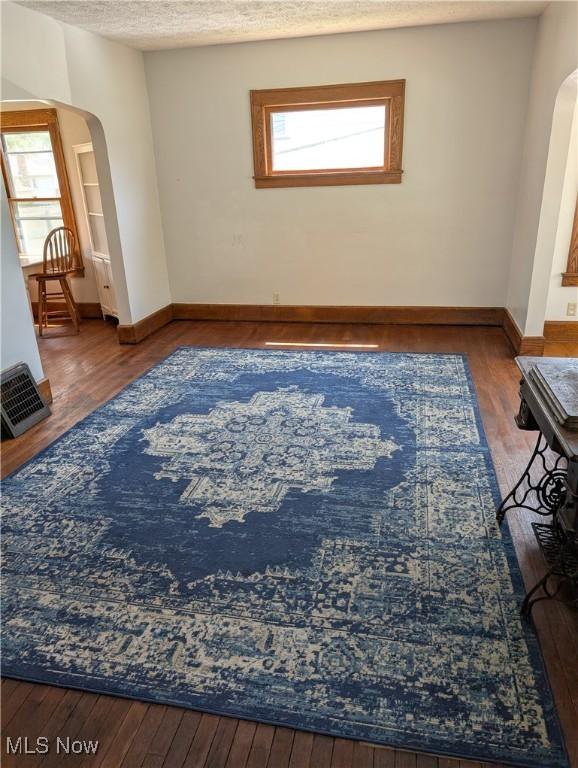 630 N Lincoln Ct, Louisville, OH 44641 - living area featuring arched walkways, healthy amount of natural light, wood finished floors, and a textured ceiling