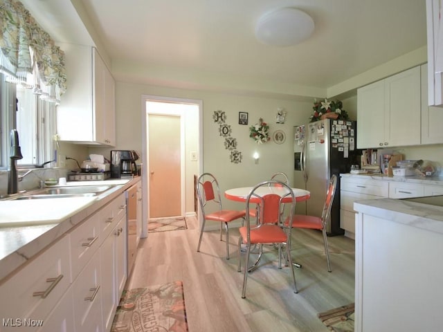 4628 Monticello Blvd, South Euclid, OH 44143 - kitchen with light wood-style floors, white cabinets, a sink, light countertops, and appliances with stainless steel finishes
