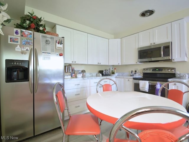 4628 Monticello Blvd, South Euclid, OH 44143 - kitchen featuring appliances with stainless steel finishes, white cabinetry, and light countertops