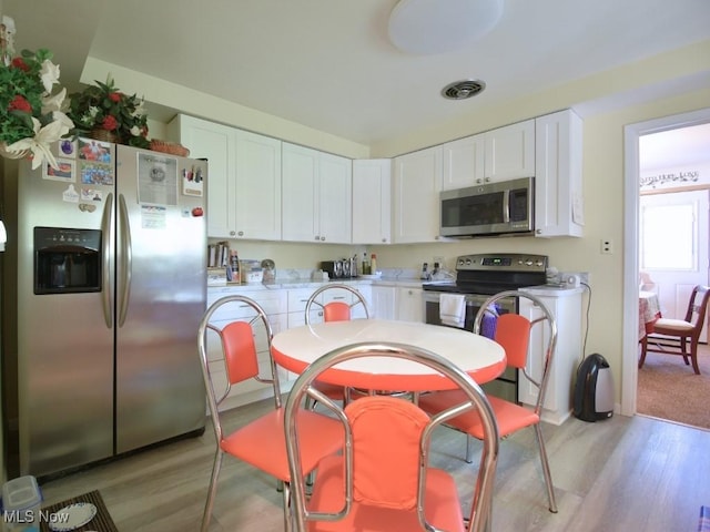 4628 Monticello Blvd, South Euclid, OH 44143 - kitchen featuring stainless steel appliances, white cabinets, light countertops, and light wood finished floors