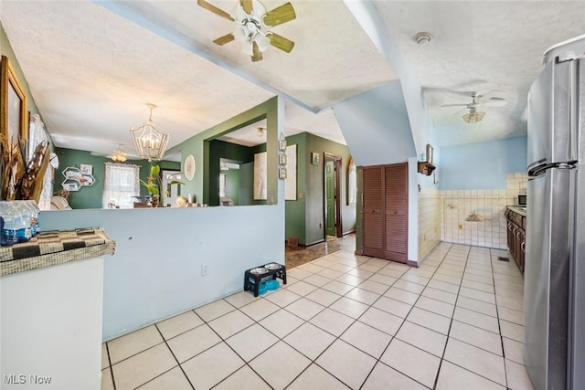 3069 Elyria Ave, Lorain, OH 44055 - kitchen featuring a ceiling fan, freestanding refrigerator, light tile patterned floors, a chandelier, and wainscoting