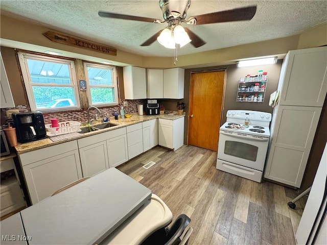 78 Findley St, Dillonvale, OH 43917 - kitchen featuring white electric range oven, a sink, a textured ceiling, light wood-style floors, and white cabinets