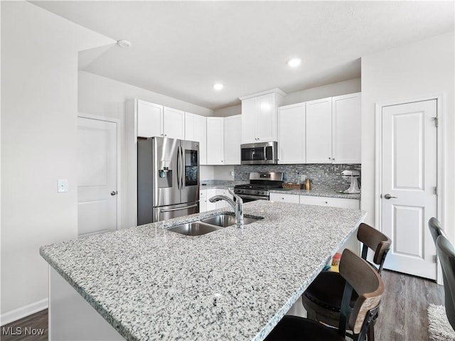 3243 Broadleaf Way, Brunswick, OH 44212 - kitchen featuring appliances with stainless steel finishes, a sink, a breakfast bar, white cabinets, and dark wood finished floors
