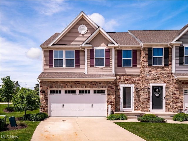 3243 Broadleaf Way, Brunswick, OH 44212 - view of front facade with an attached garage, concrete driveway, stone siding, a shingled roof, and a front lawn