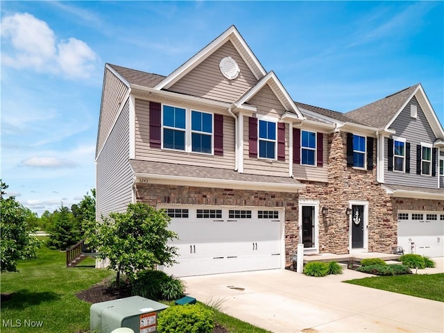 3243 Broadleaf Way, Brunswick, OH 44212 - townhome / multi-family property with stone siding, an attached garage, concrete driveway, a front lawn, and a shingled roof