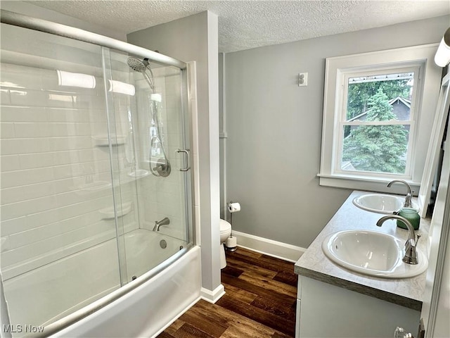177 N Cleveland Ave, Mogadore, OH 44260 - bathroom with a textured ceiling, enclosed tub / shower combo, wood finished floors, and double vanity