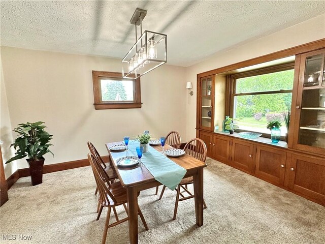 177 N Cleveland Ave, Mogadore, OH 44260 - dining space featuring light colored carpet, a textured ceiling, plenty of natural light, and a chandelier