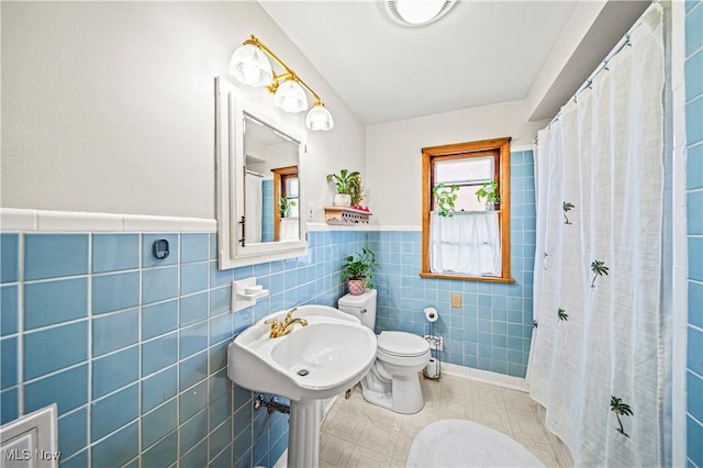 131 E 206th St, Euclid, OH 44123 - full bath with toilet, tile walls, a wainscoted wall, tile patterned floors, and a sink
